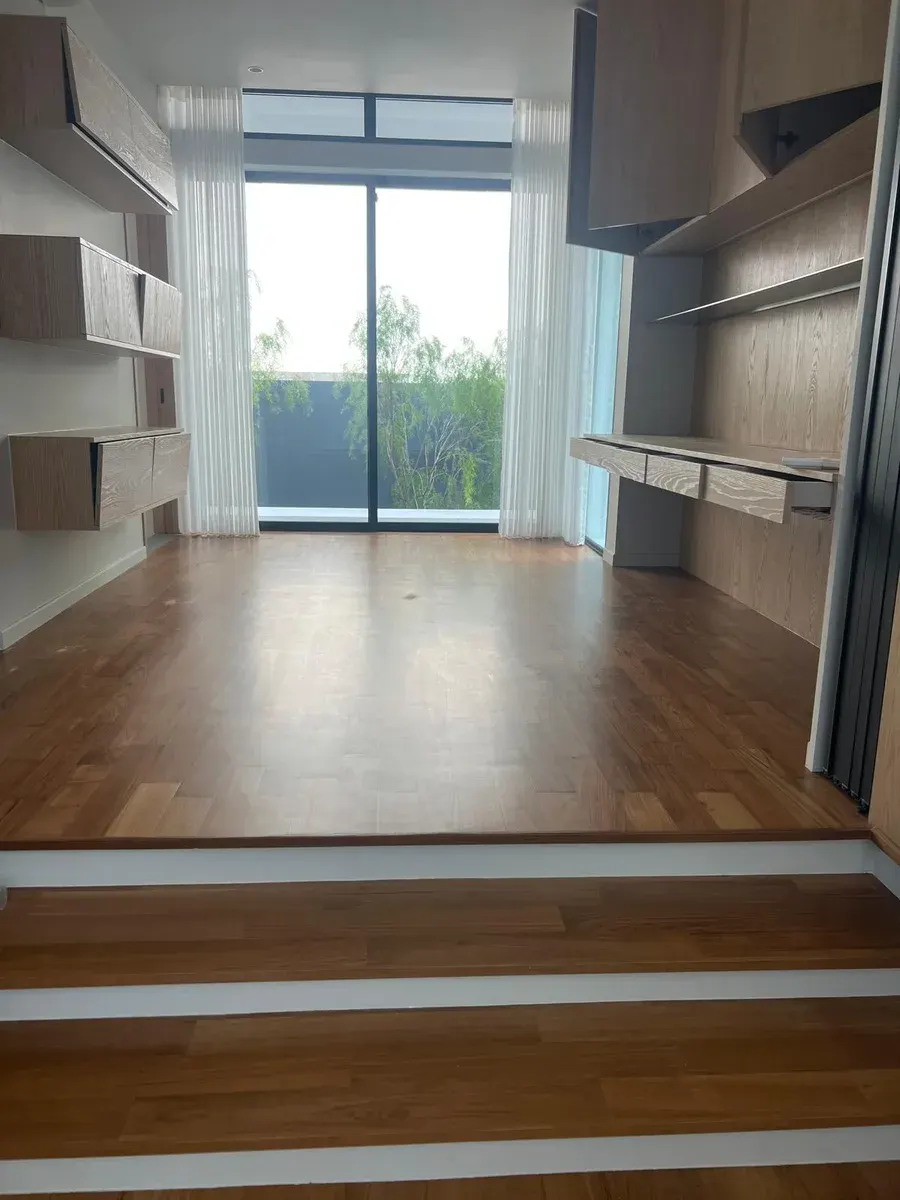 Engineered wooden flooring in a bedroom lit by natural light