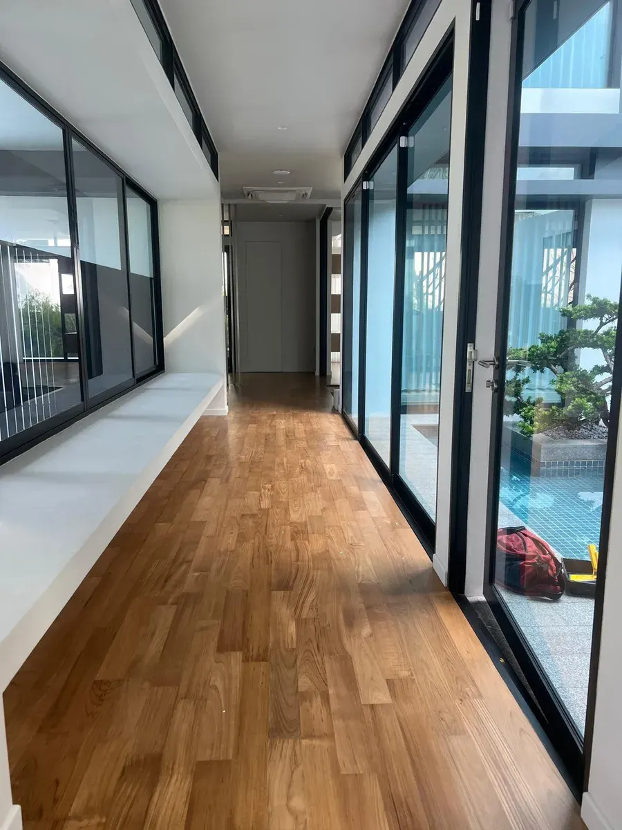 Wooden flooring running down a residential corridor with flush skirting
